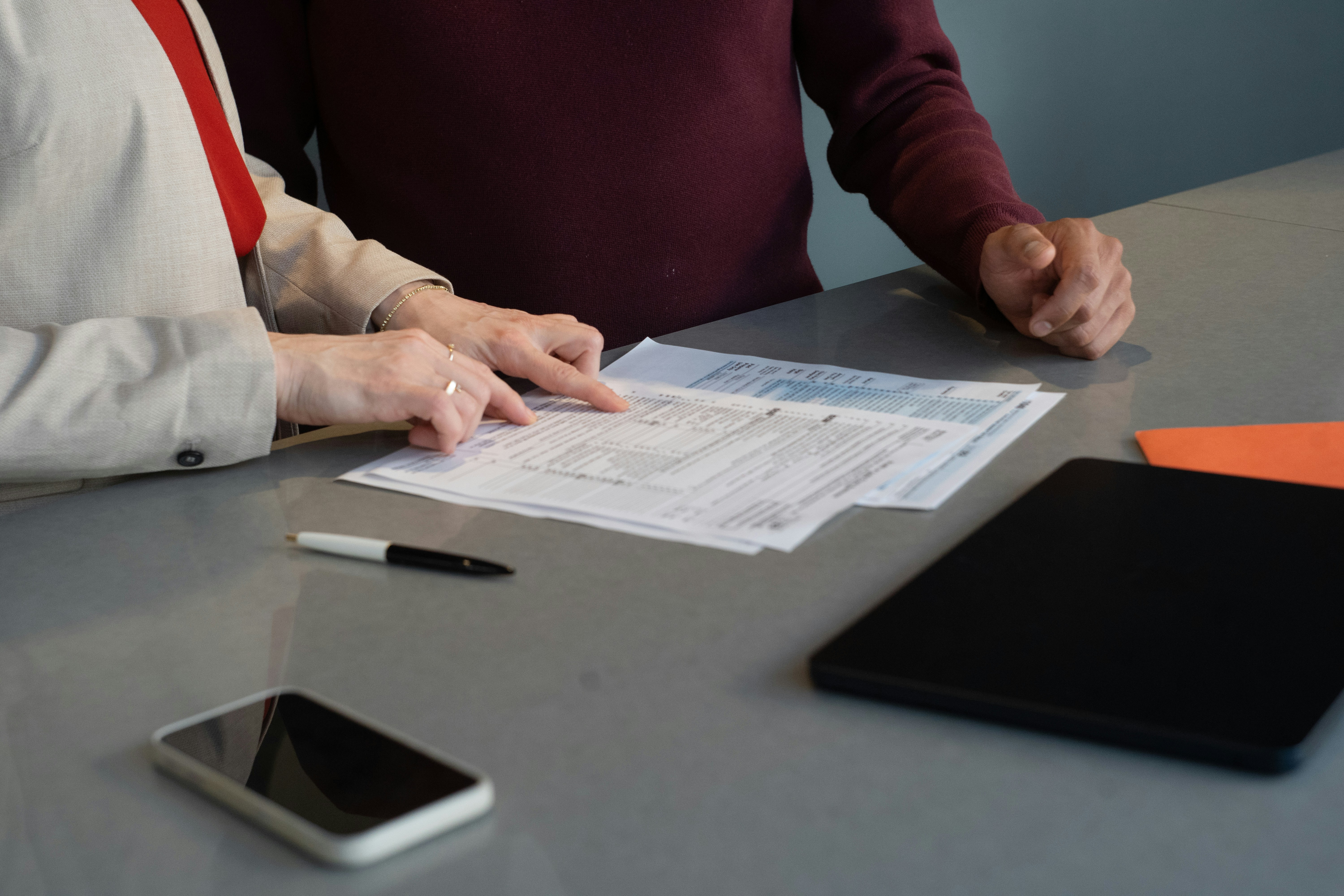 Two people review documents together at a table